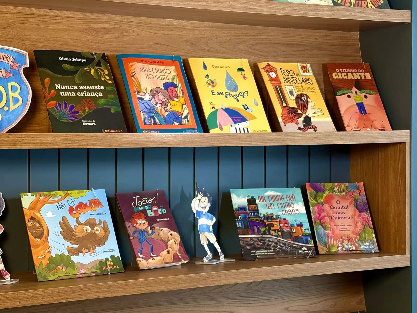 Estante com livros infantis da Editora Mixirica