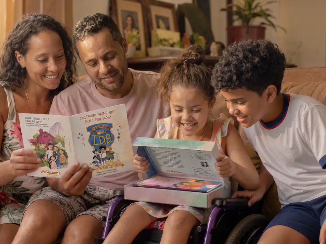 Família lendo junta um livro ilustrado da Editora Mixirica